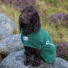 A black spaniel wearing a Dogrobes dog drying coat that has been personalised with the dog's name. 