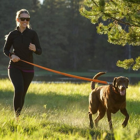 Lady running with the Ruffwear Roamer leash in orange colour
